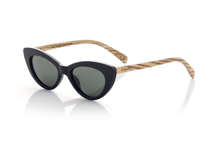 Gafas de Madera Natural de Walnut modelo MIA. Las gafas MIA son un accesorio imprescindible para las amantes de la moda retro. Con su diseño de ojo de gato, estas gafas son un complemento ideal para conseguir un look sofisticado y atemporal. La montura satinada en color negro y las varillas de madera de nogal añaden elegancia y sofisticación a su aspecto. y sus lentes verdes gradient, además de proteger tus ojos y tu piel, añaden un toque personal de color al conjunto. Sin duda, las gafas MIA son un must-have para cualquier mujer que busque un look chic y atemporal. Medida frontal 145x45mm Calibre: 50 | Root Sunglasses® 